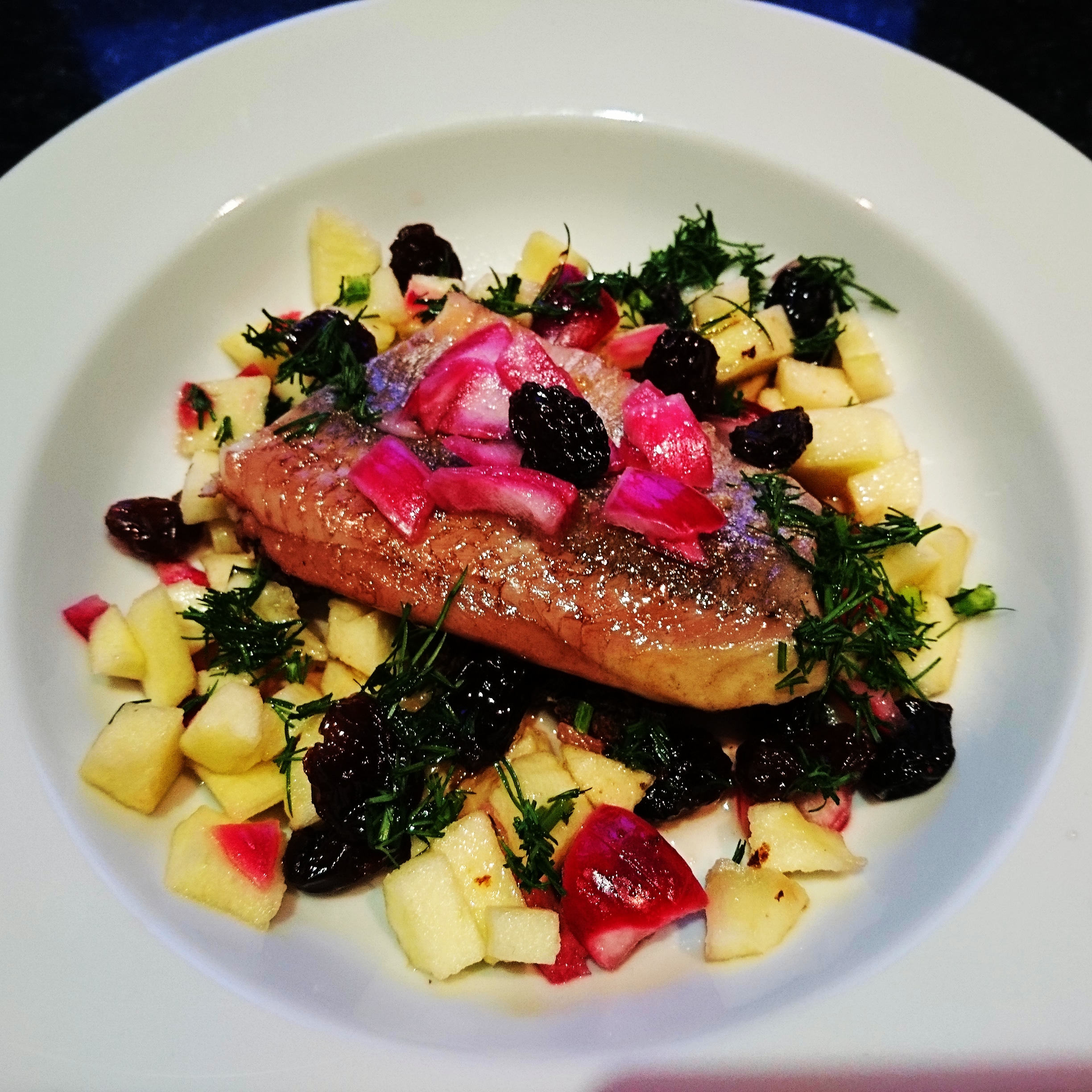 Opalany śledź z jabłkiem, marynowaną cebulą, rodzynkami i pieczonym pumperniklem